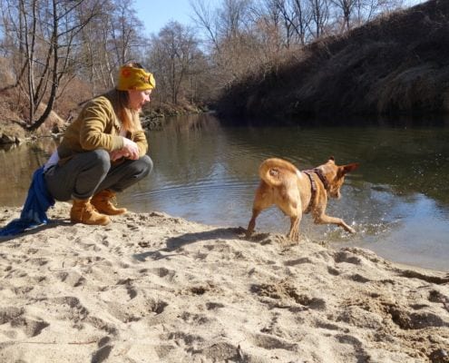 Hundetrainerin mit Hund am Fluß