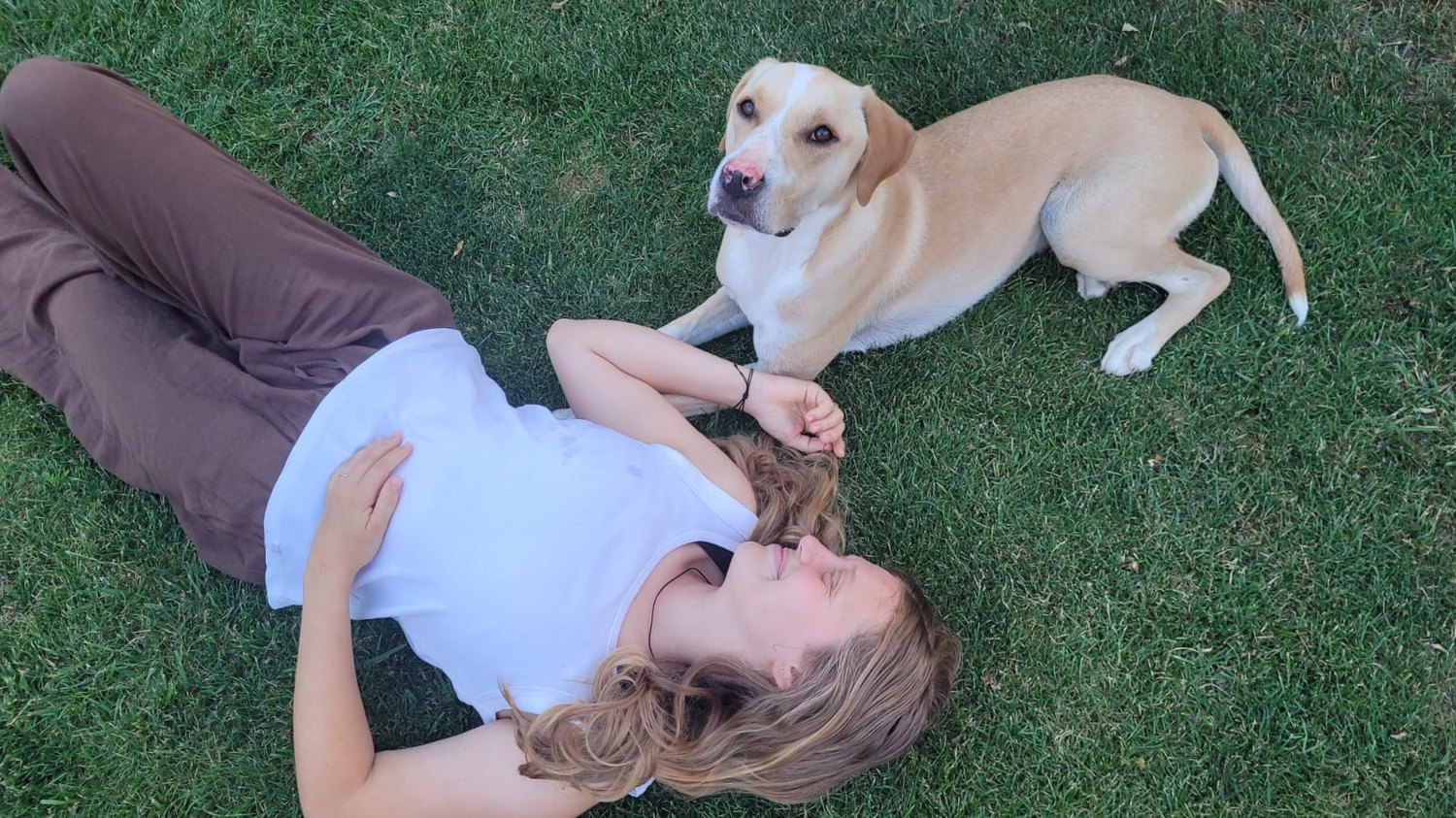 Tierkommunikatorin Katrin Ladler entspannt im Gras mit ihrem Hund Garry